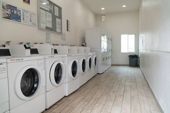 a row of washers and dryers in a laundry room